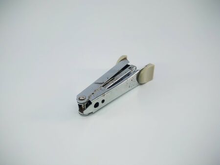 Stapler on white surface table. a device for fastening together sheets of paper with a staple or staples. A stapler is a mechanical device that joins pages of paper or similar material.の写真素材