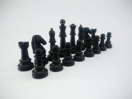 Black plastic king queen bishop knight rook pawn line up chess piece isolated on a white backgroundの写真素材