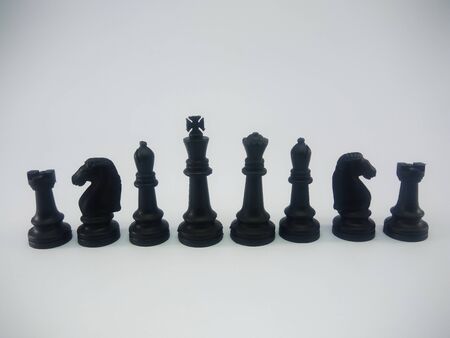 Black plastic king queen bishop knight rook line up chess piece isolated on a white backgroundの写真素材