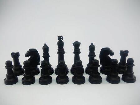 Black plastic king queen bishop knight rook pawn line up chess piece isolated on a white backgroundの写真素材