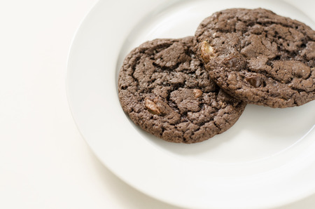 Chocolate chip and toffee cookies on a white plateの写真素材