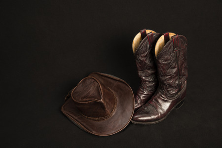 Cowboy boots and cowboy hat on black backgroundの写真素材