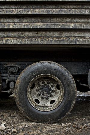 A close-up of a filthy muddy dirty dump truck tire on a wet soggy day. Close details of the muck and mudの写真素材