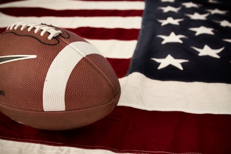 Football, America's favorite sport. A ball on a vintage Old Glory.の写真素材
