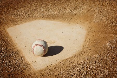 A baseball sitting on home plate. Great sports background