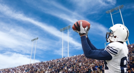 Football Player catching a touchdown passの写真素材