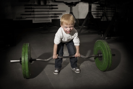 Determined Young Boy trying to lift Heavy weightsの写真素材
