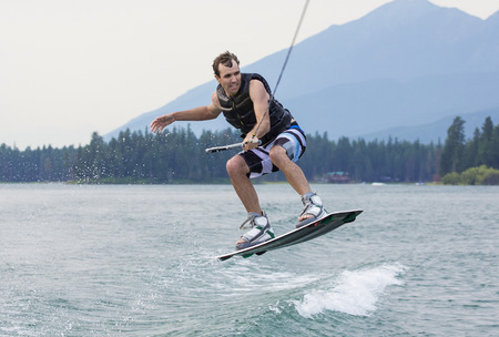 Man wakeboarding on a beautiful mountain lakeの写真素材