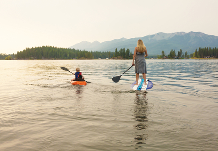 Paddle boarding on scenic mountain lake at dusk
