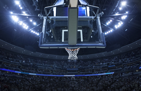 Brightly lit Basketball backboard in a large sports arena.