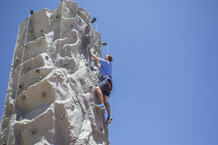 Man Rock Climbing Outdoors on an artificial wallの写真素材