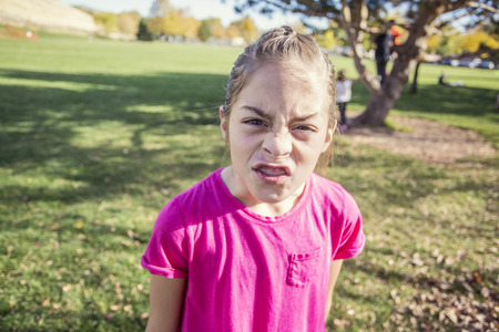 A little girl having an emotional outburst at the schoolyard. She is angry and upset and showing strong emotionsの写真素材