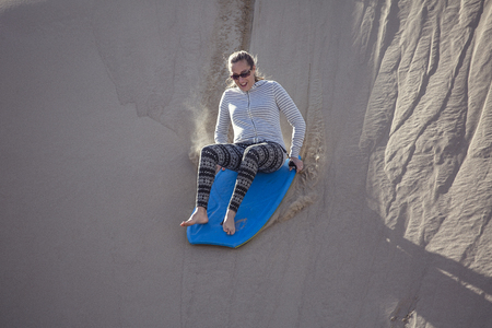 Thrill seeking woman Playing in the Sand Dunes Outdoor Lifestyleの写真素材