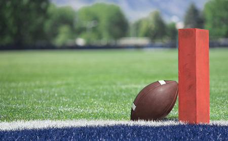Football field low end zone view. Selective focus photo of the pylon and touchdown line on a football field. Low angle view from the end zoneの写真素材