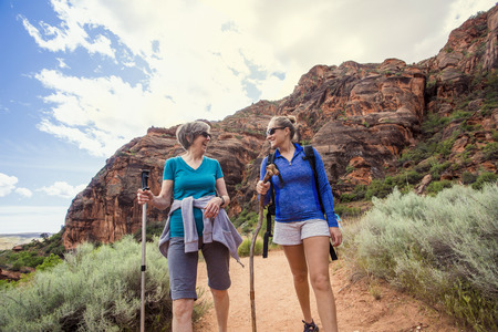 Women hiking together in a beautiful red rock canyonの写真素材