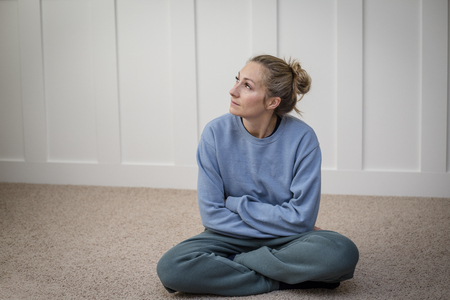 woman deep in thought struggle with depression while attempting to meditate or pray in her home. Abstract photo of a woman contemplating life`s challengesの写真素材