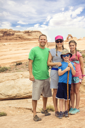 Family hiking and sightseeing together at Arches National Parkの写真素材