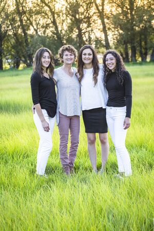 Outdoor Portrait of a beautiful family, a mother and her daughters. Vertical portrait of beautiful...
