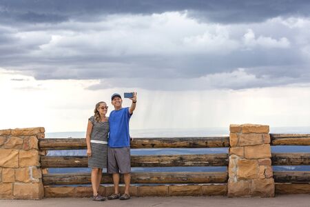 Couple taking a selfie photo together on a high mountain top at a national parkの写真素材