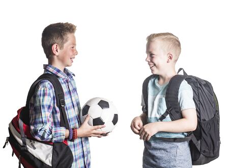 Two smiling boys playing together at school. Two friends talking together isolated on a white backgroundの写真素材