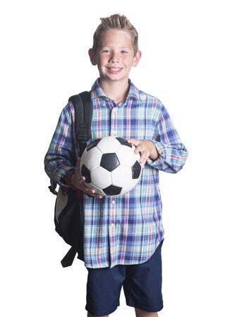 Portrait of a Handsome young elementary school aged boy smiling and holding a soccer ball. Isolated on a white backgroundの写真素材