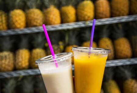 Two glasses of tropical fruit smoothies. Delicious refreshing drinks. Pina Colada and pineapple...