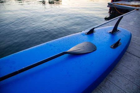 Close up view of a stand up paddle sitting on the edge of the lakeの写真素材