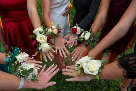 A circle of wrist corsages before a school prom dance. Beautiful group of girls wearing traditional flowers at the homecoming danceの写真素材