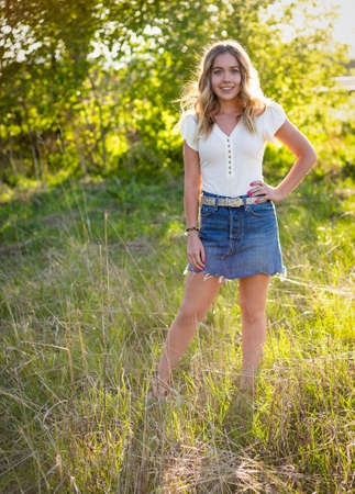 Portrait of a Beautiful confident young woman standing in a grass field on a summer evening. Real peopleの写真素材
