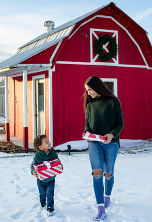Young diverse boy and Beautiful diverse teen girl delivery Christmas presents to their friends and family.の写真素材