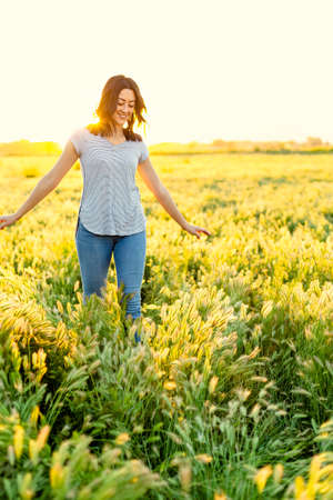 Portrait of a smiling Happy woman walking among the wild flowers in a large field on a summer...