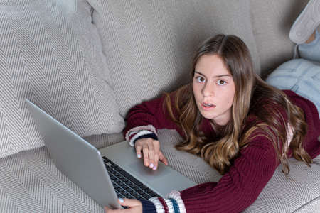 Teen girl upset by being monitored by her parents of her online screen time. Concept image of how parents should monitor how their child spend their time onlineの写真素材