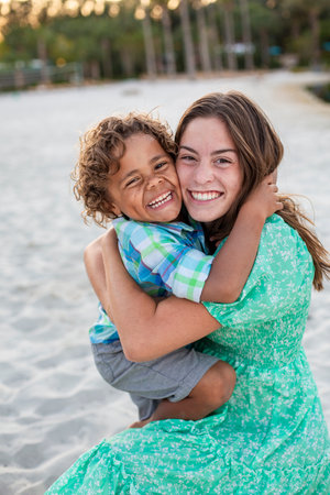 Portrait of two beautiful diverse children smiling and hugging each other. A hispanic girl and African American boy showing pure joy and beautiful smiles.の写真素材