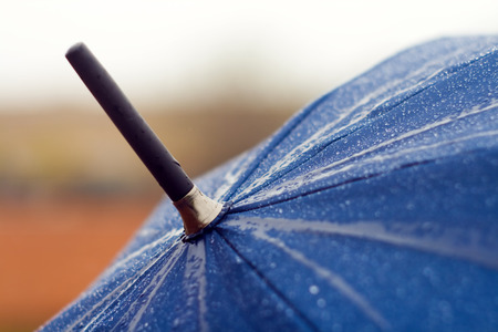 Blue umbrella close up with rain drops on itの写真素材