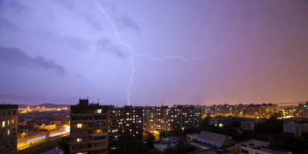 Lightning flashing over night rainy summer city