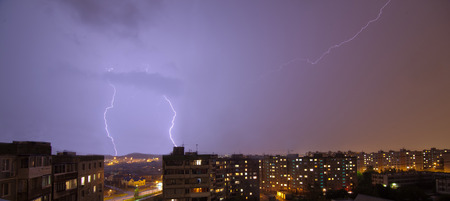 Lightning flashing over night rainy summer city