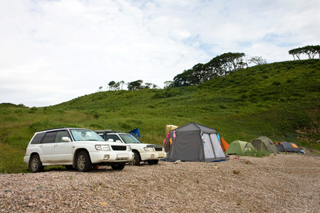 Two cars and camp at the sea shoreの写真素材