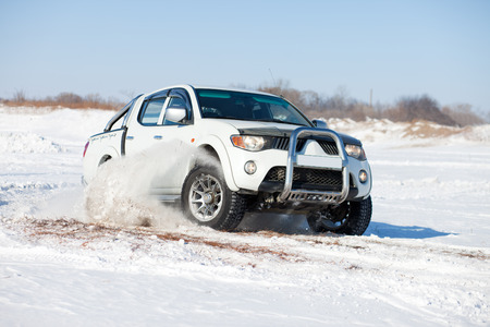 White truck traveling in the snowの写真素材