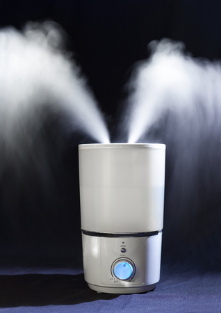 Humidifier spreading steam in a dark roomの写真素材