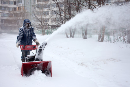 KHABAROVSK, RUSSIA - DECEMBER 03, 2015: A man removing snow with a snowblower during snowstormのeditorial素材