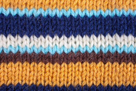 Stropped knitted background. Blue, white, orange, brown and turquoise