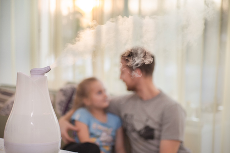 Humidifier with father and daughter on the backgroundの写真素材