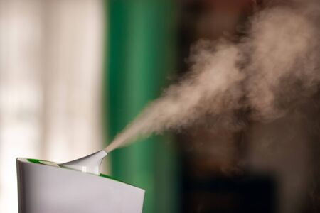 Humidifier spreading steam into the living roomの写真素材