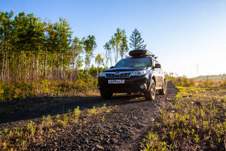 Khabarovsk, Russia - May 23, 2020: Subaru Forester with roof box at dirt road in the forest