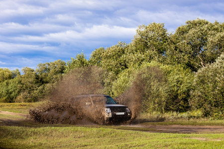 Japanese SUV moving by a puddle making a lot of water splashes