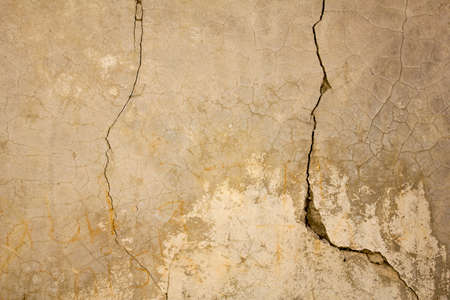 old gray white concrete wall with deep and small cracks. rough texture.
