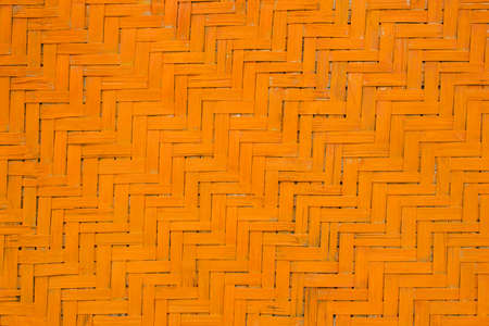 Orange yellow leaf woven from palm leaves. natural surface texture. vertical and horizontal linesの写真素材