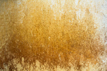 old dirty white wall with yellow green spots of paint and mold with moss. rough surface texture