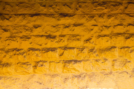 yellow wall of large bricks with shadow. rough surface textureの写真素材
