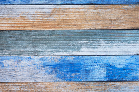 old wooden board with bright blue and beige paint and cracks. horizontal lines. rough surface textureの写真素材